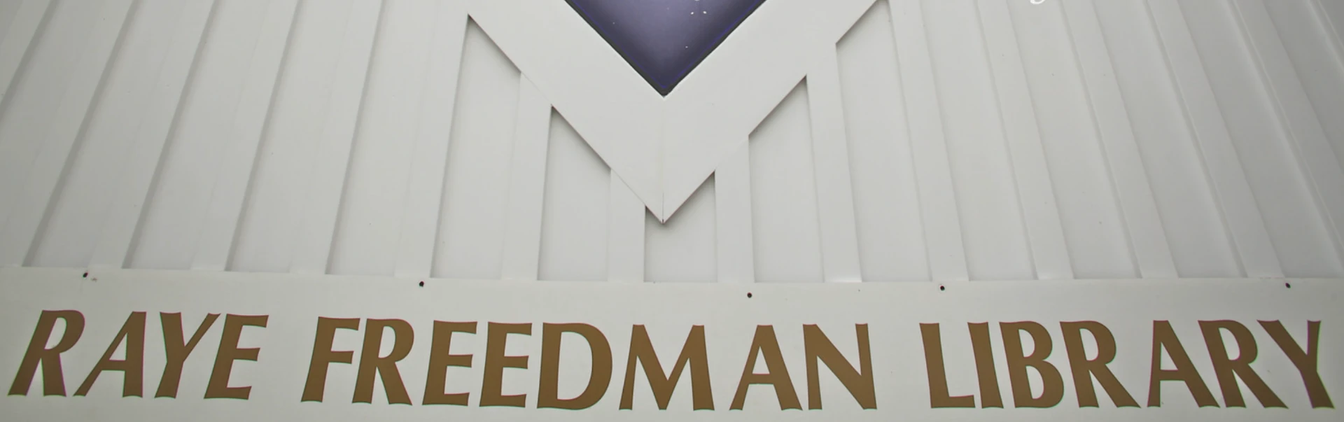 Gold lettering reading Raye Freedman Library